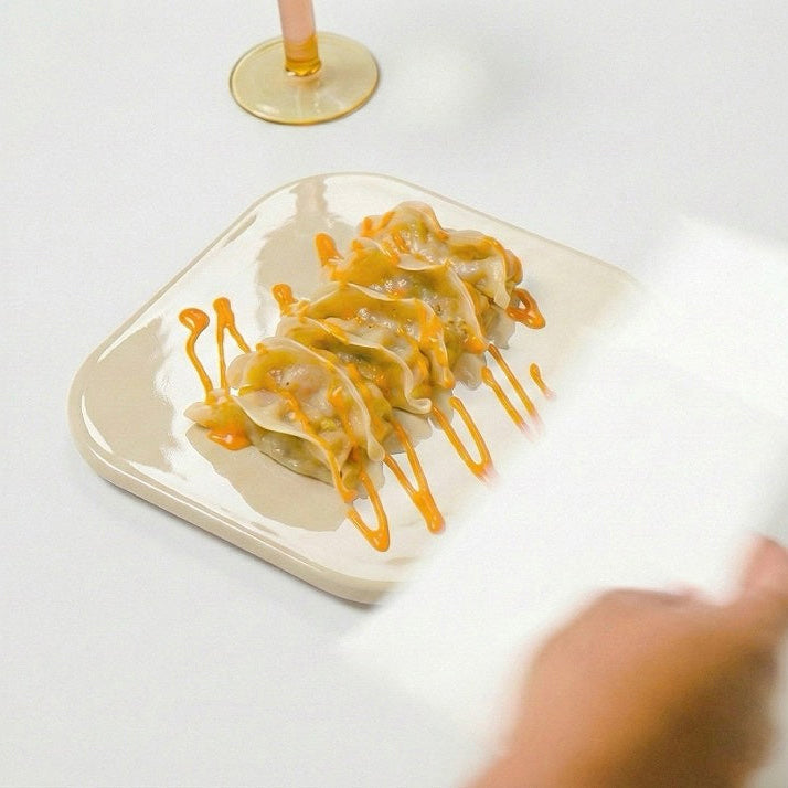 Gyoza mit Sauce auf cremefarbenem PLAYTS